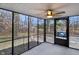 Open screened porch with view to wooded backyard and an ornate metal door at 11035 W Lakeshore Dr, Carmel, IN 46033