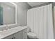 Bright bathroom featuring a vanity with a sink, toilet, and a shower with a white shower curtain at 1135 Sherwood Dr, Danville, IN 46122
