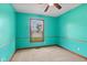 A cozy bedroom with teal walls, neutral carpet, ceiling fan, and a window with a view of the outdoors at 1135 Sherwood Dr, Danville, IN 46122