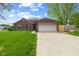 Charming brick home with a two-car garage and a well-manicured lawn at 1135 Sherwood Dr, Danville, IN 46122