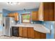 This kitchen features wood cabinets, stainless appliances, and a window overlooking the yard at 1135 Sherwood Dr, Danville, IN 46122