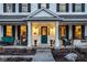 Inviting front porch with seating area, columns, and a charming teal-colored front door at 13139 Dumbarton St, Carmel, IN 46032