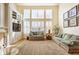 Cozy living room featuring built-in shelving, a fireplace, and large windows for natural light at 13139 Dumbarton St, Carmel, IN 46032