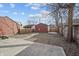 View of a spacious backyard with a concrete patio, walkway, shed, and wooden fence at 235 E 11Th St, Indianapolis, IN 46202