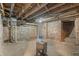Unfinished basement with exposed brick, wooden beams, and utility equipment at 235 E 11Th St, Indianapolis, IN 46202