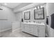 Bright bathroom with double sinks, grey cabinets, and modern light fixtures at 235 E 11Th St, Indianapolis, IN 46202
