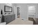 Neutral bathroom features a gray vanity with granite counters, a framed mirror, and a walk in closet at 235 E 11Th St, Indianapolis, IN 46202