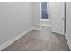 Empty bedroom featuring hardwood floors, white trim, and a bright window at 235 E 11Th St, Indianapolis, IN 46202