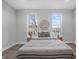 Bright bedroom features two windows, wood floors, and decorative mirror above the bed at 235 E 11Th St, Indianapolis, IN 46202