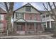 Charming red brick two-story home with a welcoming front porch and professionally landscaped front yard at 235 E 11Th St, Indianapolis, IN 46202
