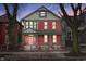 Charming red brick two-story home with a welcoming front porch and professionally landscaped front yard at 235 E 11Th St, Indianapolis, IN 46202