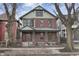 Charming red brick two-story home with a welcoming front porch and professionally landscaped front yard at 235 E 11Th St, Indianapolis, IN 46202