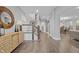 Elegant foyer featuring hardwood floors, wooden staircase, stylish console table with decor, and a view of the dining area at 235 E 11Th St, Indianapolis, IN 46202