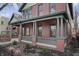 A welcoming front porch adorned with brick columns and a cozy seating area. Landscaped yard with a black metal fence at 235 E 11Th St, Indianapolis, IN 46202