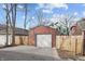 View of detached garage with a concrete pad and wooden fence at 235 E 11Th St, Indianapolis, IN 46202