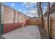 View of a backyard with a detached garage, concrete pad, and wooden fence at 235 E 11Th St, Indianapolis, IN 46202
