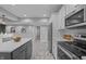 Bright kitchen featuring stainless appliances, white cabinets, granite counters and a gray kitchen island at 235 E 11Th St, Indianapolis, IN 46202
