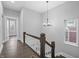 A staircase featuring neutral colors, wood floors and banister, decorative lighting, and many windows at 235 E 11Th St, Indianapolis, IN 46202