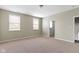 Empty bedroom with two windows, neutral carpeting, and a closet at 2605 Carrollton Ave, Indianapolis, IN 46205