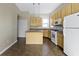 Cozy kitchen with island, light wood cabinets, and white appliances at 2605 Carrollton Ave, Indianapolis, IN 46205