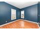 Bedroom with hardwood floors, two windows and dark blue painted walls at 2914 N Delaware N St, Indianapolis, IN 46205
