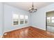 Bright dining room with three windows, hardwood floors, a chandelier and an open doorway to another room at 2914 N Delaware N St, Indianapolis, IN 46205