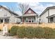 Charming two-story home featuring a covered front porch, red door, and a picket fence surrounded by lush greenery at 2914 N Delaware N St, Indianapolis, IN 46205