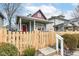 Inviting curb appeal with a red front door, covered porch, and a freshly installed wooden fence surrounding the property at 2914 N Delaware N St, Indianapolis, IN 46205