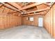 View of garage interior showing concrete floor, wooden walls, lighting, and door to the backyard at 2914 N Delaware N St, Indianapolis, IN 46205