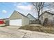 A detached garage with a white garage door, light green siding, and a fenced yard at 2914 N Delaware N St, Indianapolis, IN 46205