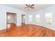 Spacious living room with gleaming hardwood floors, a ceiling fan, and several windows providing natural light at 2914 N Delaware N St, Indianapolis, IN 46205