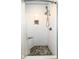 Updated shower with multi-setting head, pebble floor, shower seat, and tiled walls at 2914 N Delaware N St, Indianapolis, IN 46205