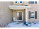 Inviting covered front porch with a decorative wreath, stylish chair and snowy surroundings at 5303 Brandywine Dr, Whitestown, IN 46075