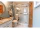 Bathroom featuring sliding door shower, white fixtures and a round mirror at 6006 Regency Dr, Columbus, IN 47203