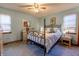 Bedroom featuring a ceiling fan, an iron bed frame, a dresser and bright windows at 6006 Regency Dr, Columbus, IN 47203
