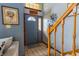 Inviting entryway featuring tile flooring, and a blue front door leading to a staircase with wooden banister at 6006 Regency Dr, Columbus, IN 47203