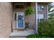 Inviting front entrance featuring a blue door with wreath, brick facade, and potted plants creating a welcoming atmosphere at 6006 Regency Dr, Columbus, IN 47203