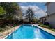 Backyard pool surrounded by mature trees, privacy fence, and outdoor seating areas at 6006 Regency Dr, Columbus, IN 47203