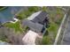 An aerial view showcases the home with driveway, mature trees and access to a lake at 6045 Channel Dr, Columbus, IN 47201