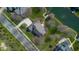 An aerial view showcases the home with driveway, mature trees and access to the water at 6045 Channel Dr, Columbus, IN 47201