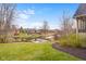 A serene backyard view showcasing a well-manicured lawn and pond, perfect for tranquil outdoor living at 6045 Channel Dr, Columbus, IN 47201