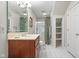 Bright bathroom featuring white tiled floor, wooden vanity, and shower with floral curtain at 6045 Channel Dr, Columbus, IN 47201