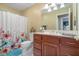 Full bathroom with wood cabinets and shower with patterned shower curtain at 6045 Channel Dr, Columbus, IN 47201