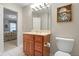 Neutral bathroom featuring vanity, a large mirror, toilet and flamingo wall art at 6045 Channel Dr, Columbus, IN 47201