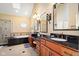 Luxurious bathroom with double vanities, granite countertops, a soaking tub, and elegant lighting fixtures at 6045 Channel Dr, Columbus, IN 47201