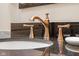 Close-up of a bathroom sink with a unique bronze faucet and black granite countertop at 6045 Channel Dr, Columbus, IN 47201