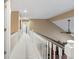 Hallway with white railings, beige walls, and a view of other rooms at 6045 Channel Dr, Columbus, IN 47201
