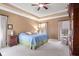 Bright main bedroom showcasing a tray ceiling, neutral tones, and plenty of natural light from multiple windows at 6045 Channel Dr, Columbus, IN 47201