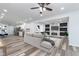 Open living room shows a sleek ceiling fan, hardwood floors, modern fireplace and television focal point at 650 S Lyons Ave, Indianapolis, IN 46241