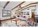 Comfortable living area showcasing vaulted ceilings, exposed beams, a brick fireplace, and ample seating at 7326 Caboose Ct, Indianapolis, IN 46256